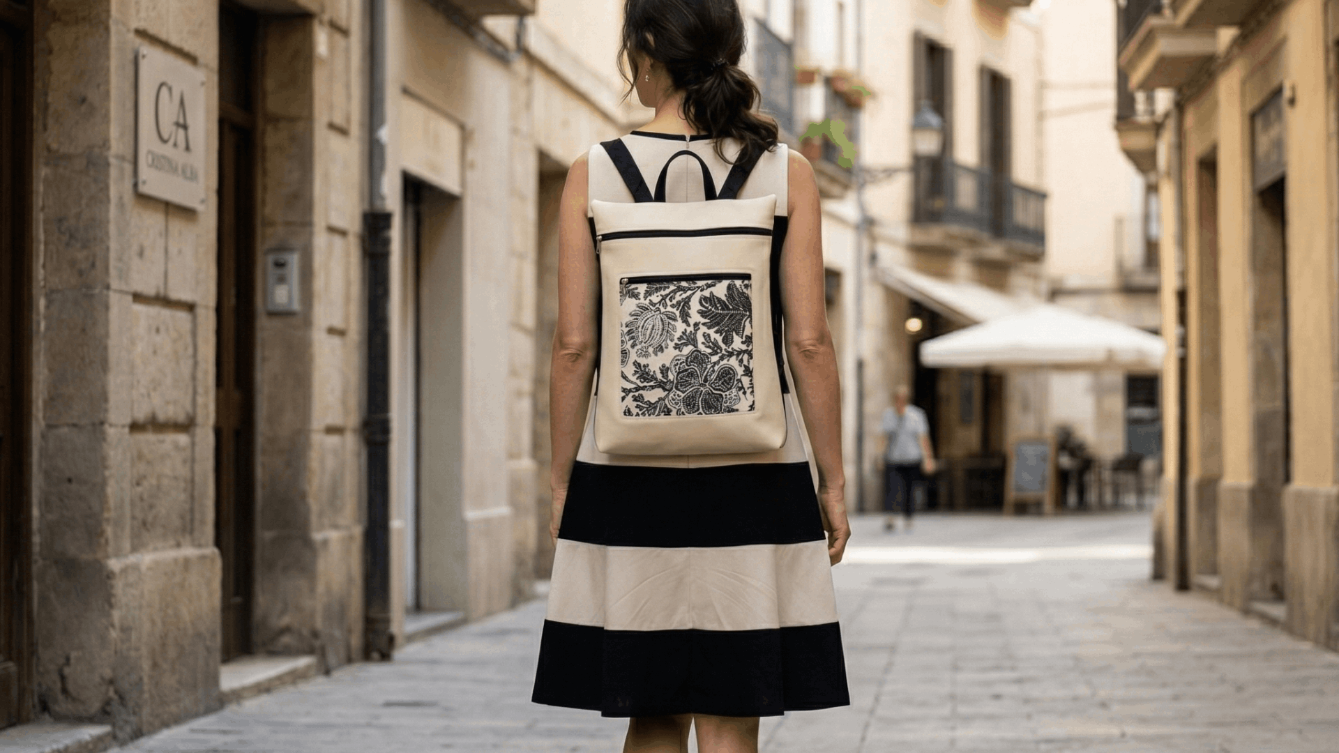 Mujer caminando por la calle con mochila antirrobo reversible Cristina Alba