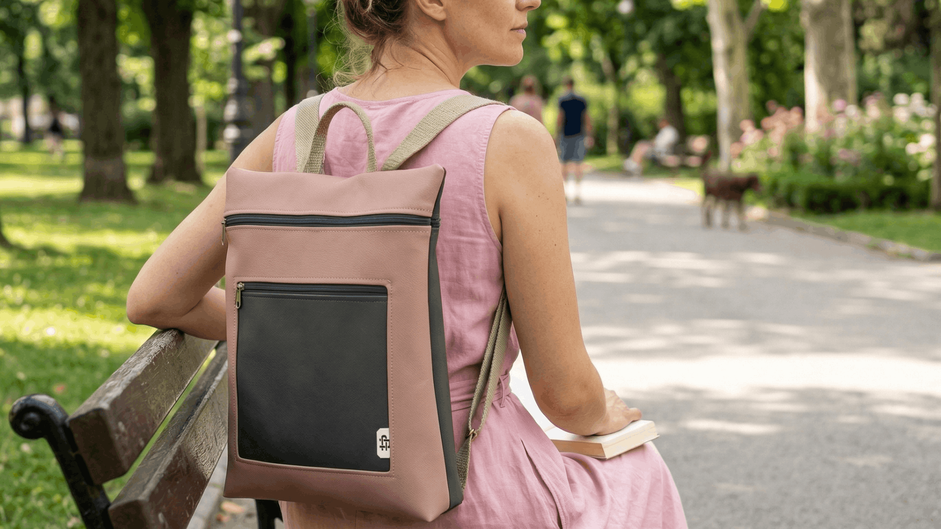 Mujer sentada en un parque con mochila antirrobo reversible Cristina Alba