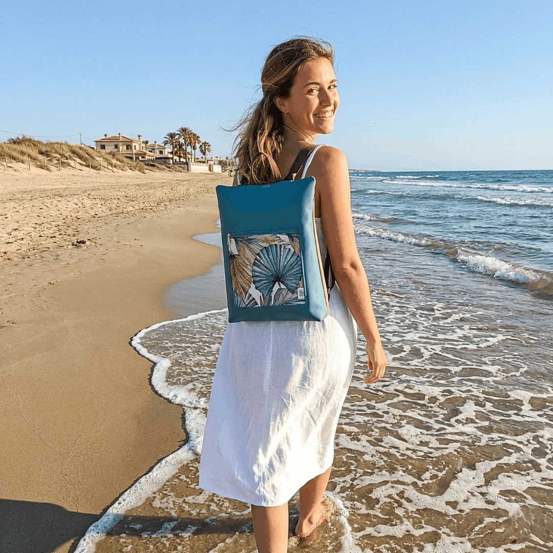 mujer-sonriente-llevando-mochila-antirrobo-tropizal-turquesa-cristina-alba